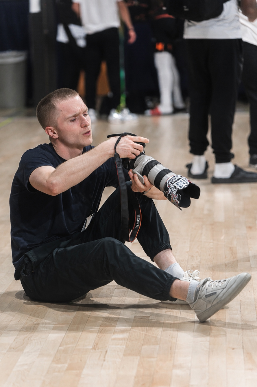 Basketball photographer seated on court