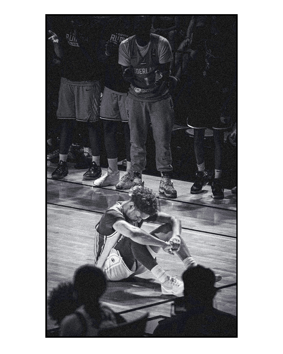 Black and white Danny Rumph Classic player sitting on the court
