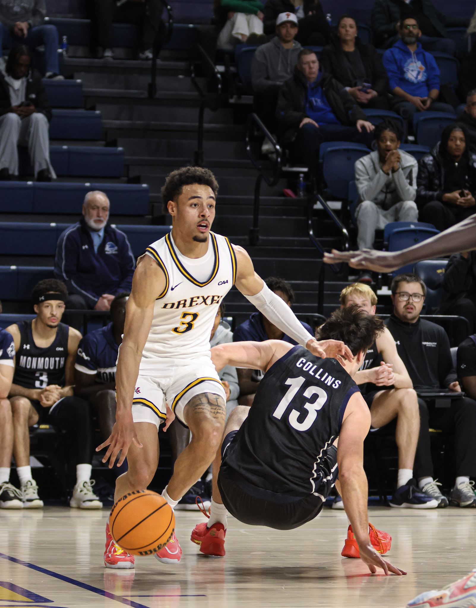 Drexel guard dribbling past a fallen defender