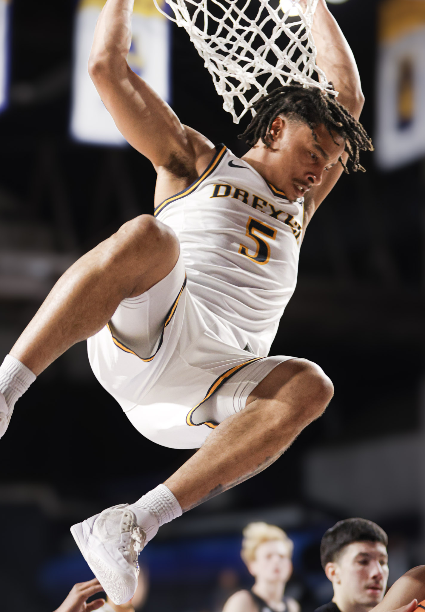 Drexel player hanging from the rim after a dunk