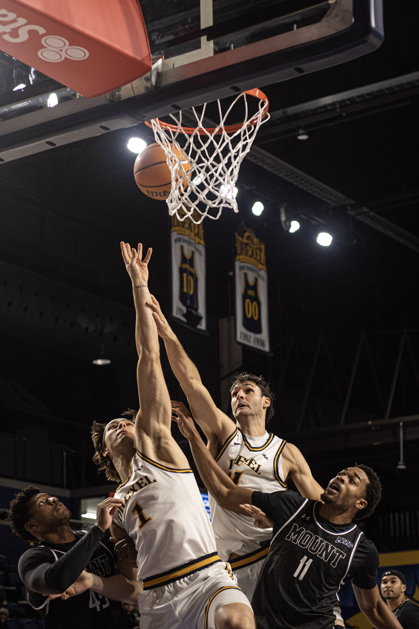 Drexel basketball players reaching at the rim