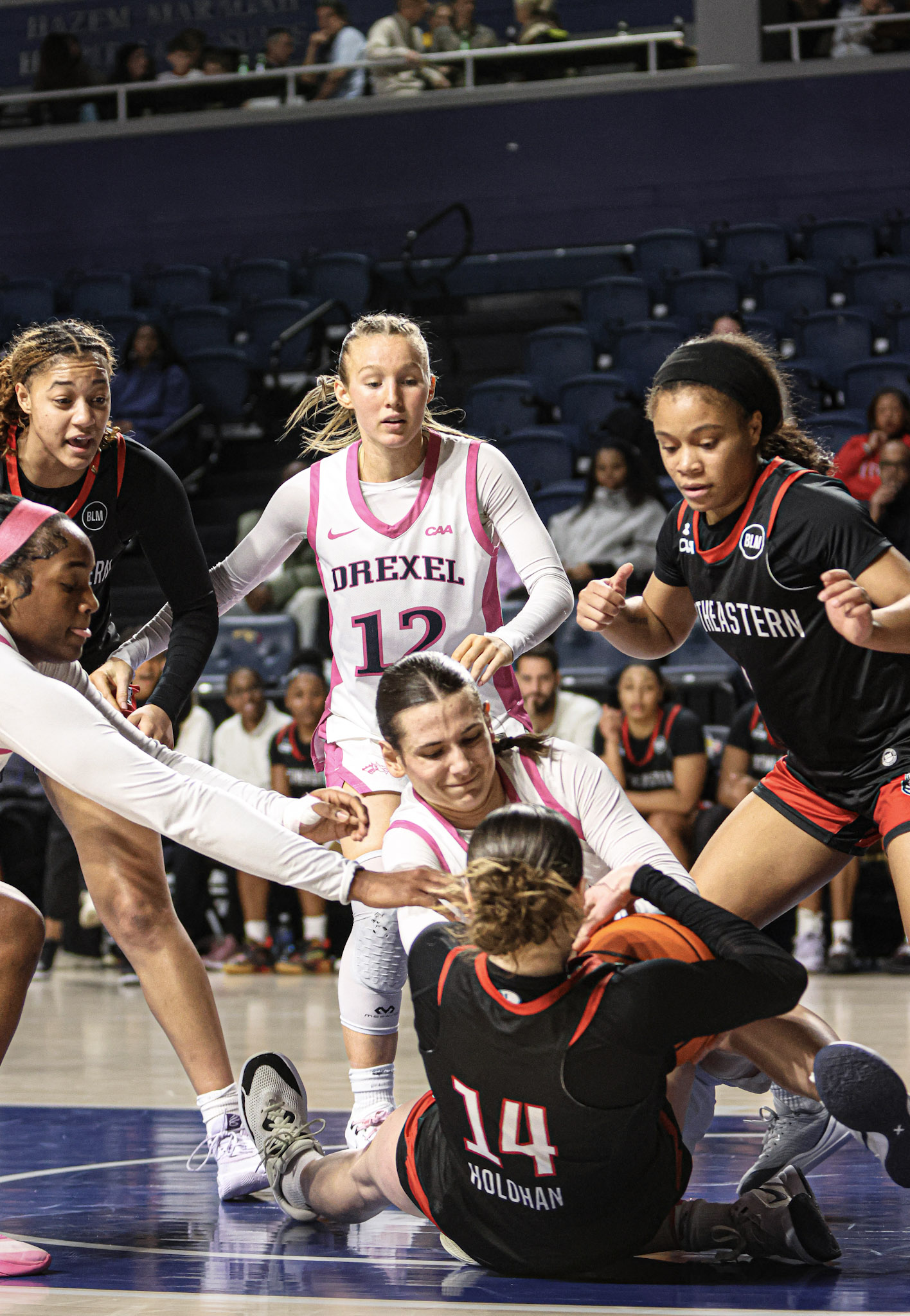 Drexel women's basketball players fighting for a loose ball