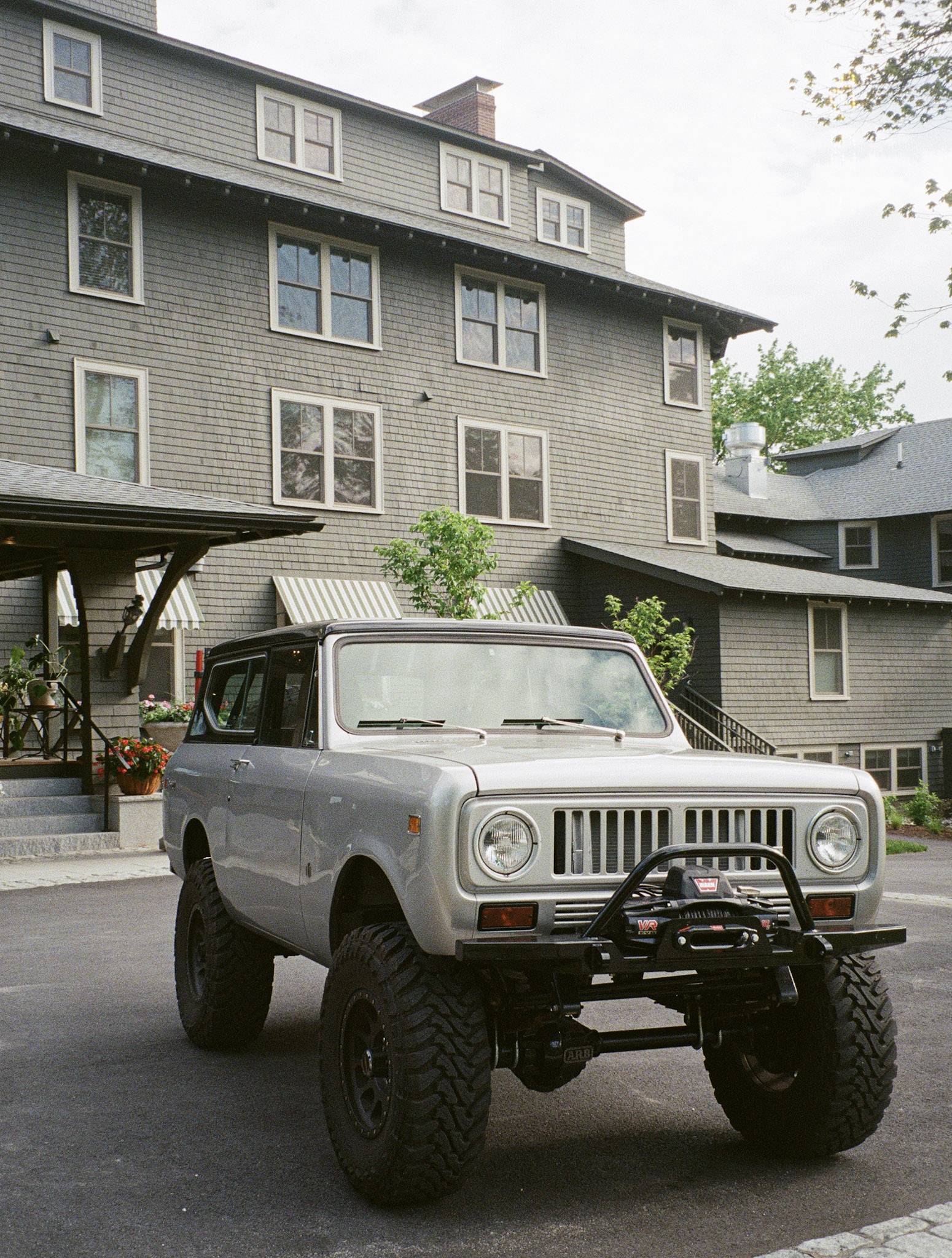 Vintage Jeep outside a shingled building on film