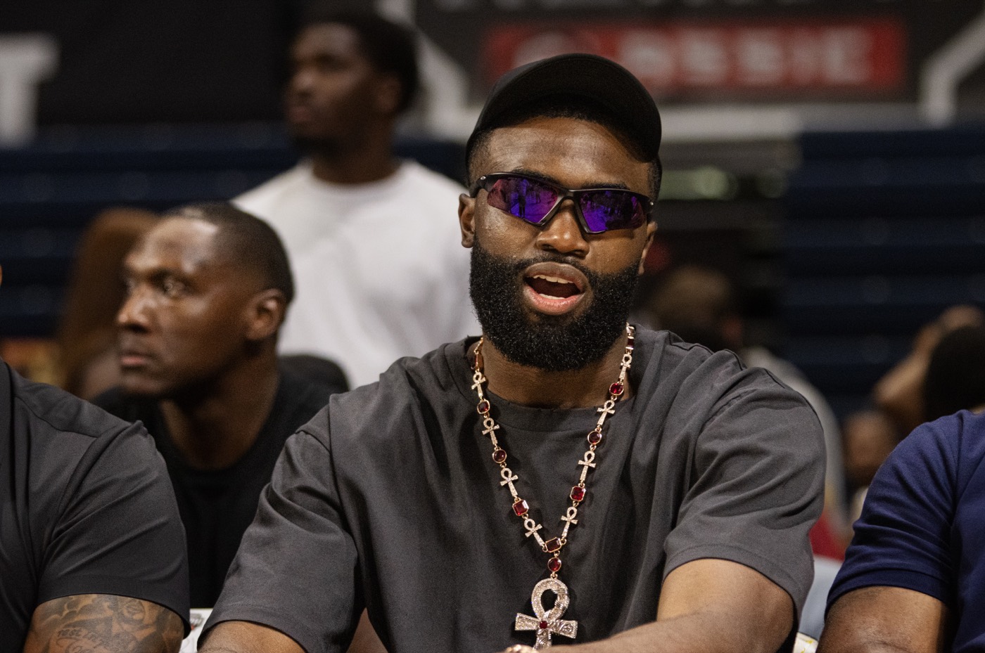 Jaylen Brown facing camera courtside with sunglasses and a statement necklace