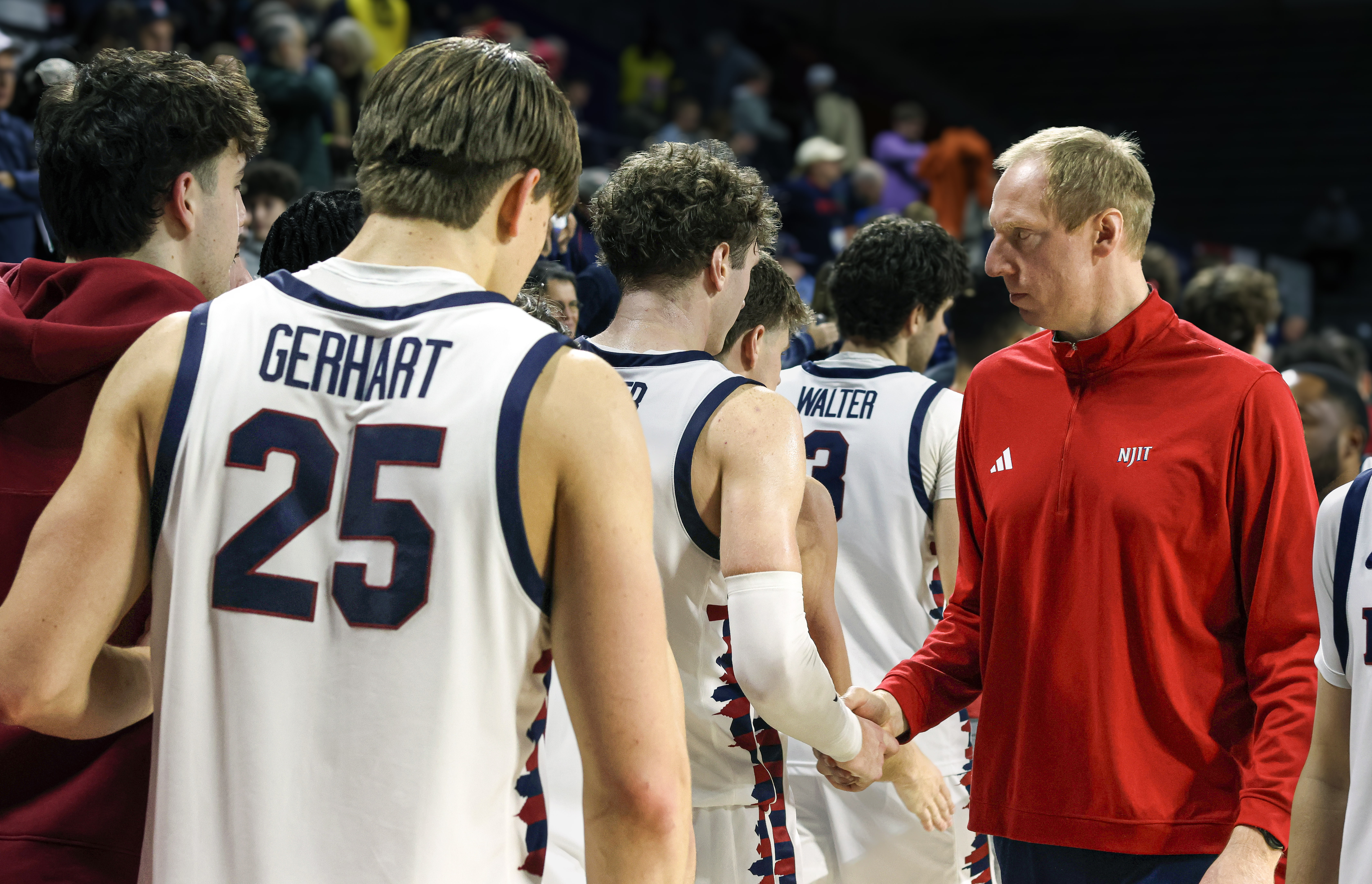 NJIT basketball coach shaking hands with players after a game