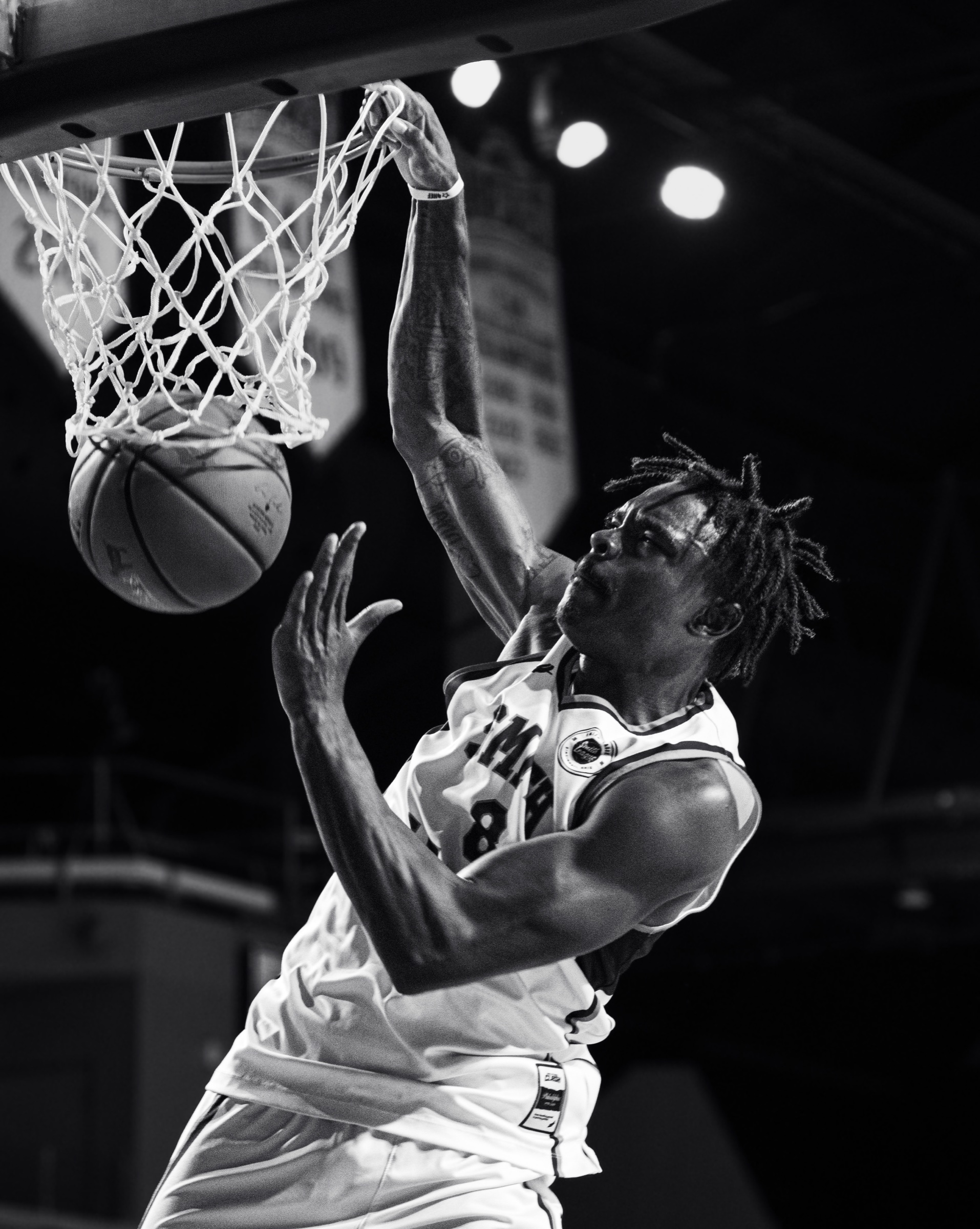 Black and white Smith League player finishing at the rim