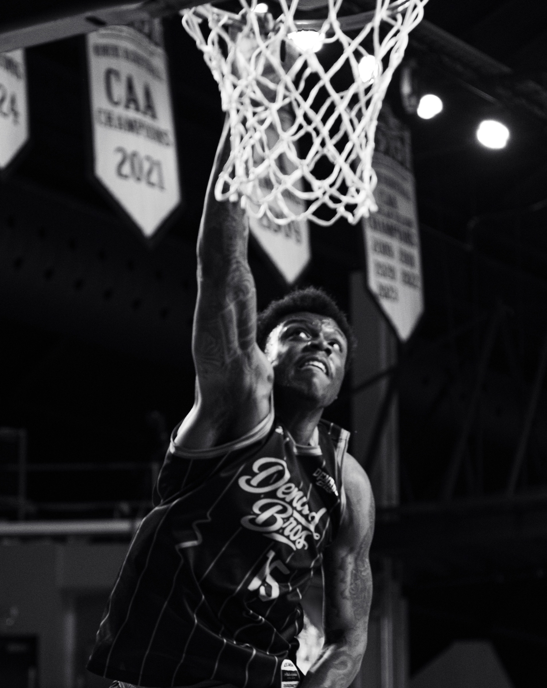 Black and white player extending for a layup at the Invitational Clash