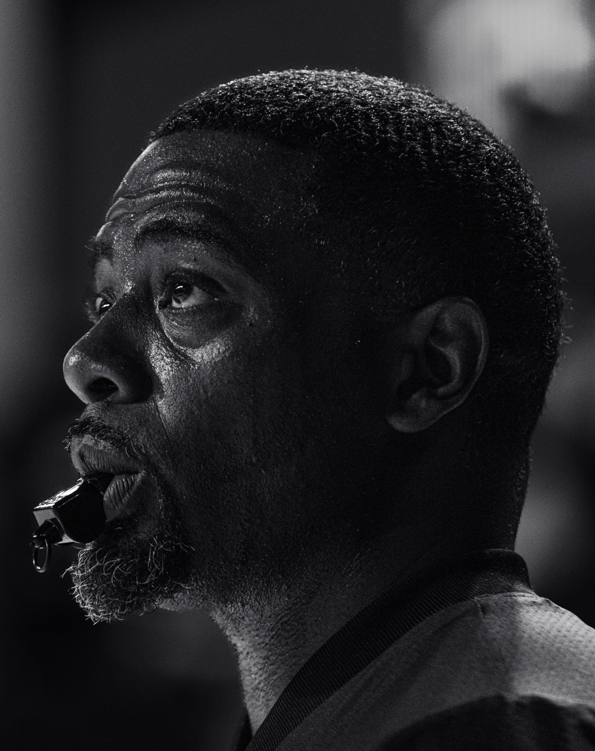 Black and white portrait of an Invitational Clash referee holding a whistle