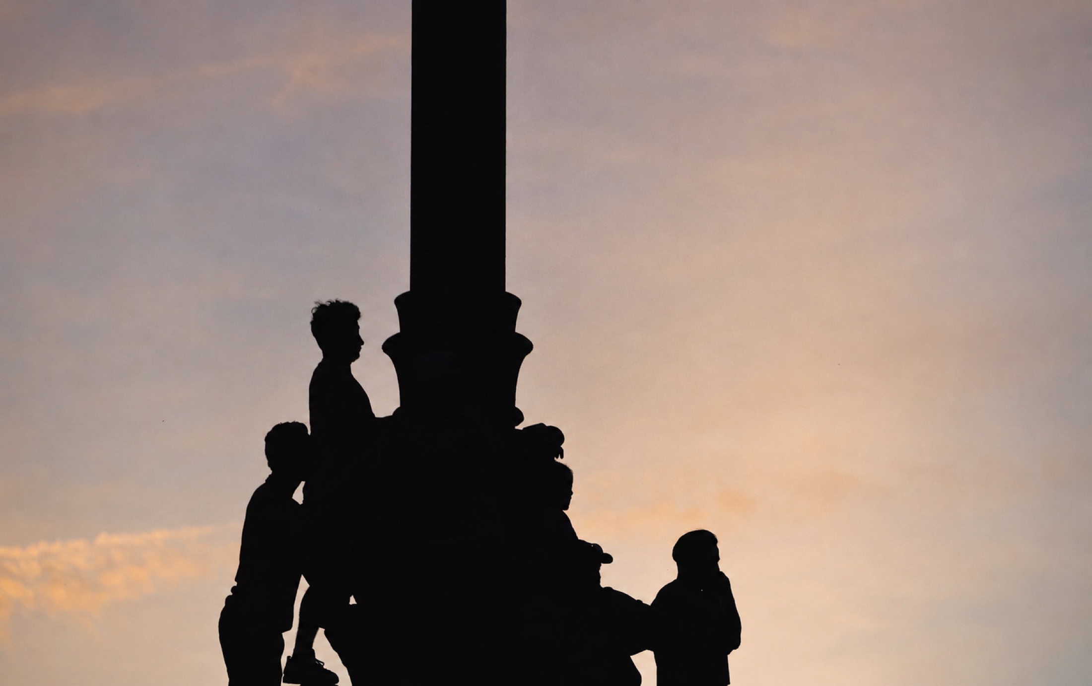 Fan silhouettes against a sunset sky