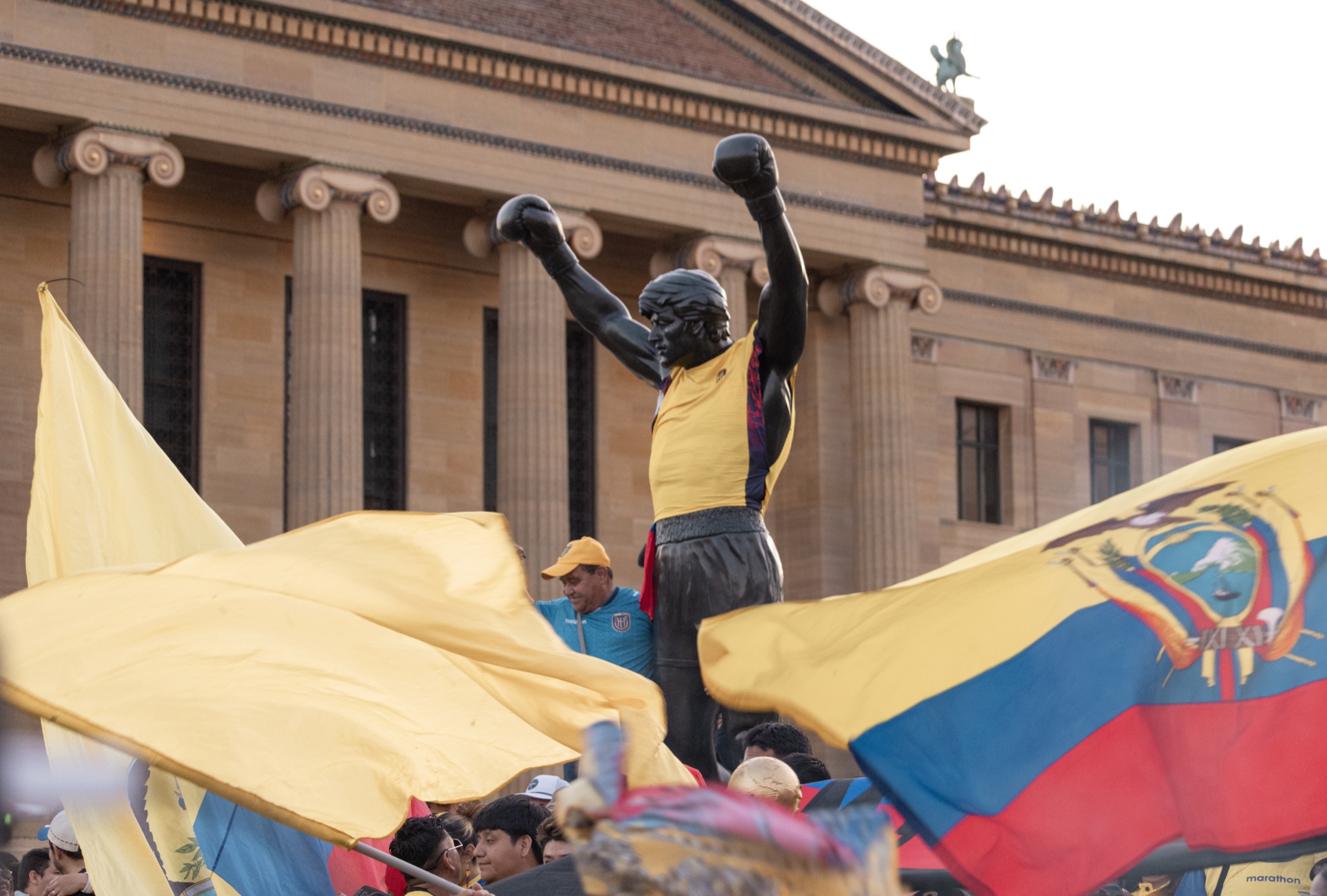 Rocky statue framed by Ecuadorian flags