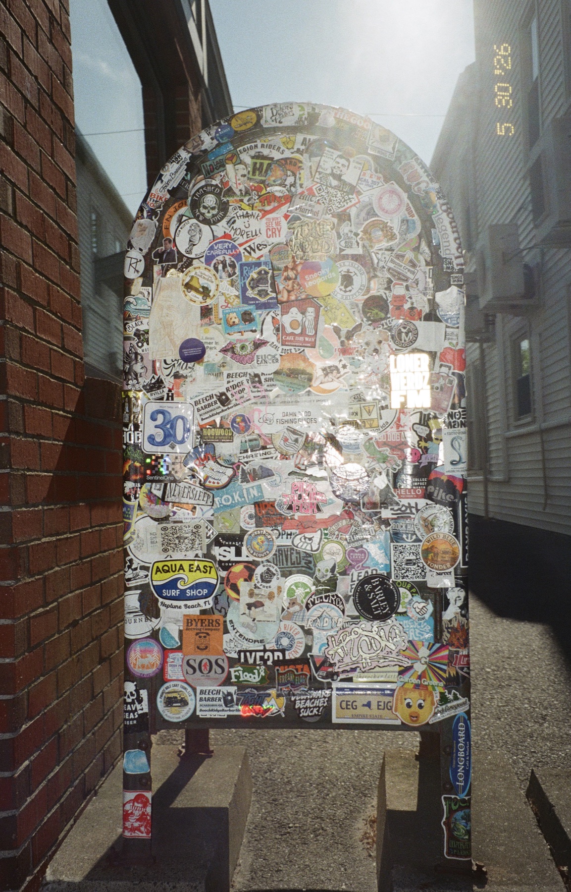 Sticker-covered sign in a Maine alley