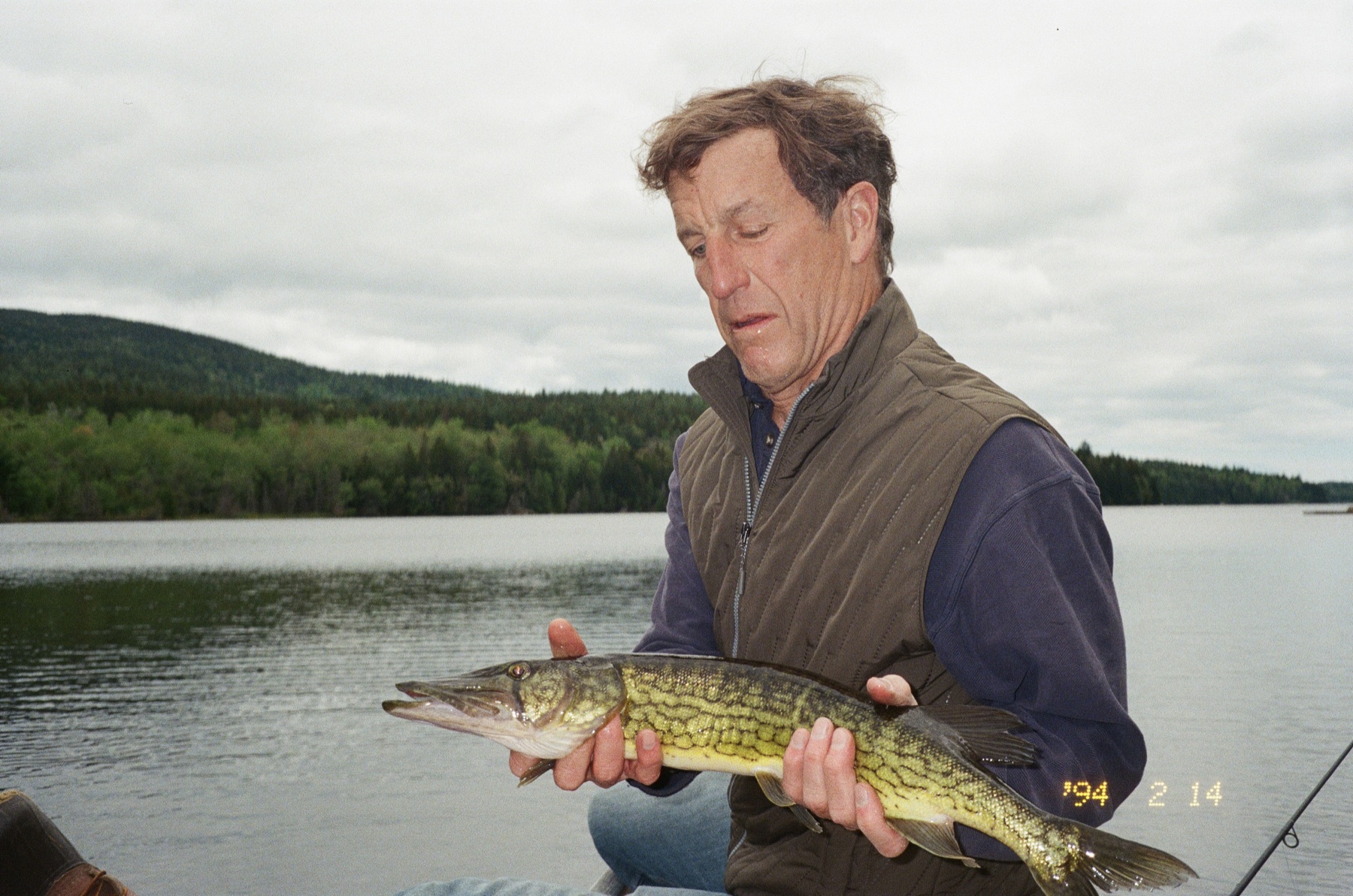 Man holding a fish on a Maine lake