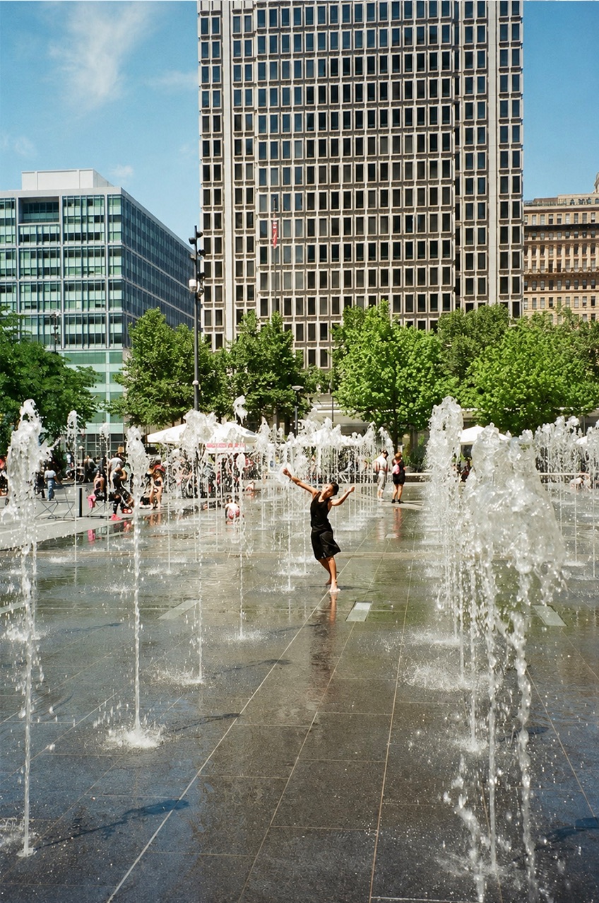 Child playing among the Dilworth Park fountains on a sunny day